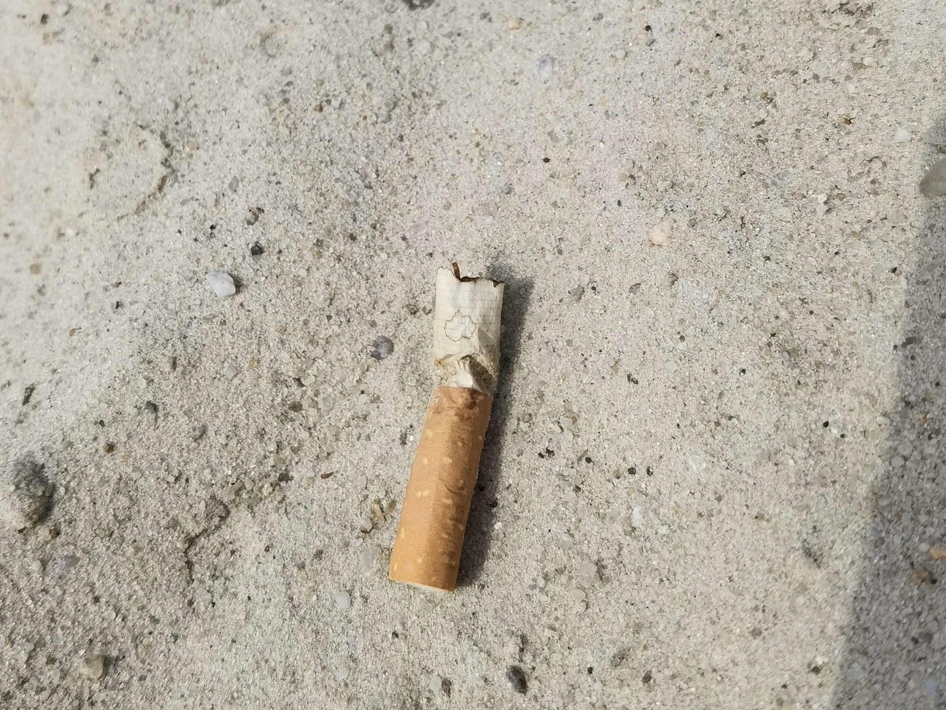 Zigarettenkippe im Sand