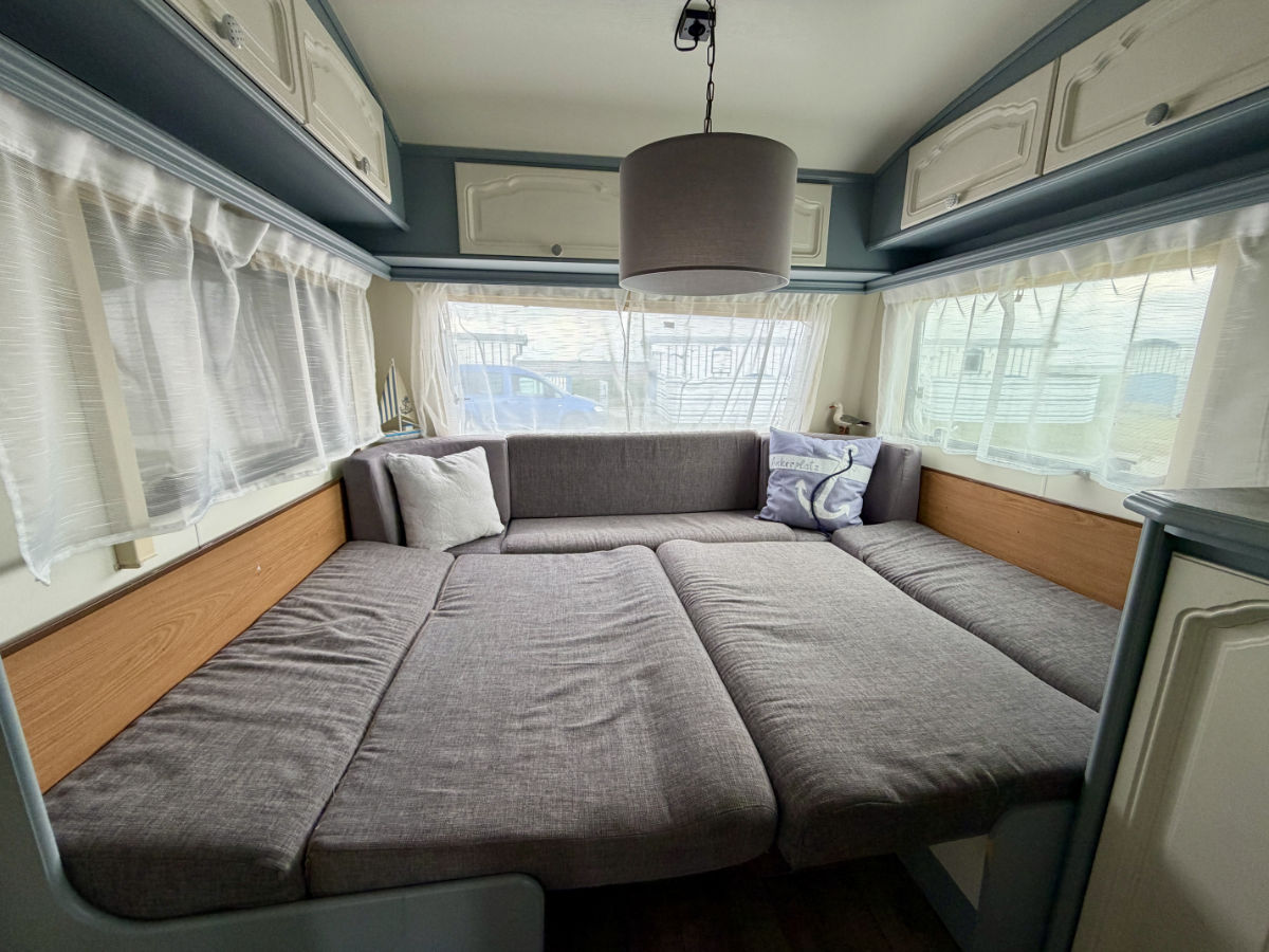 Ausklappbare Schlafecke im Mietwohnwagen auf dem Strandcampingplatz